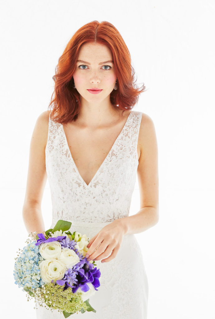 A close up shot of Isadora, a Lace v-neck wedding dress with sleek, fluted skirt.
