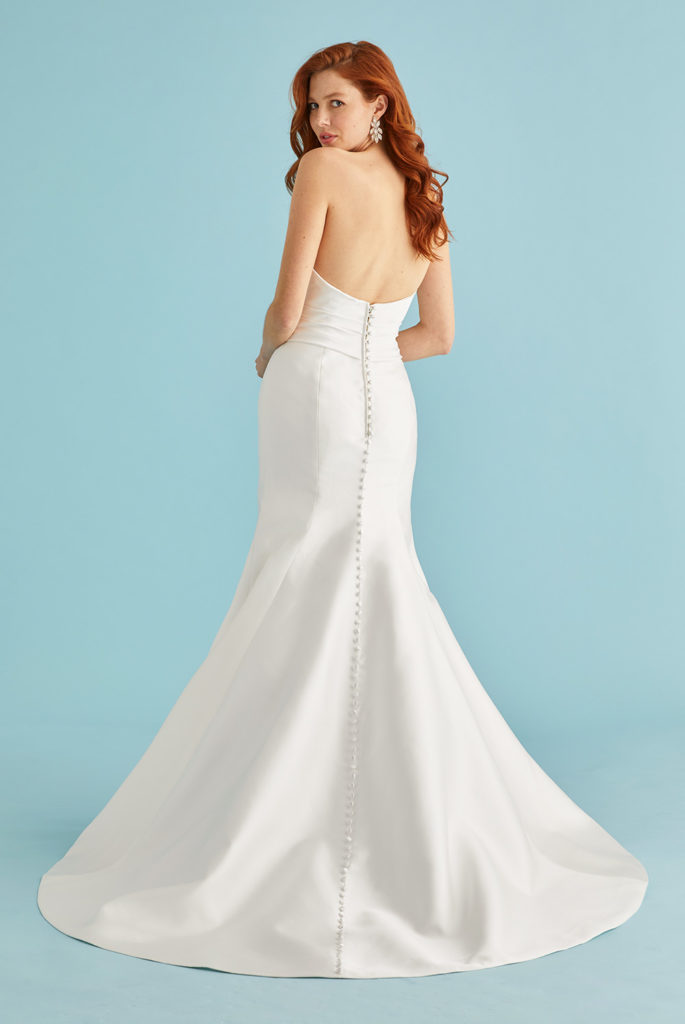 Back view of a strapless fit and flare wedding dress with button detail and chapel train by Lea-Ann Belter Bridal