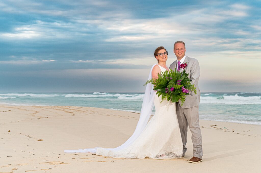 A bride and groom stand on the beach together at sunset in Punta Cana