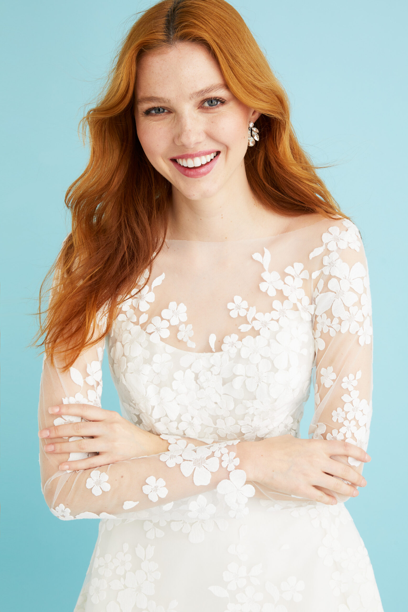 The Coralie corset wedding gown by Toronto bridal gown designer Lea-Ann Belter styled with an optional sheer embroidered jacket. The floral motif carries through the sleeves, adding an ethereal, romantic finish.