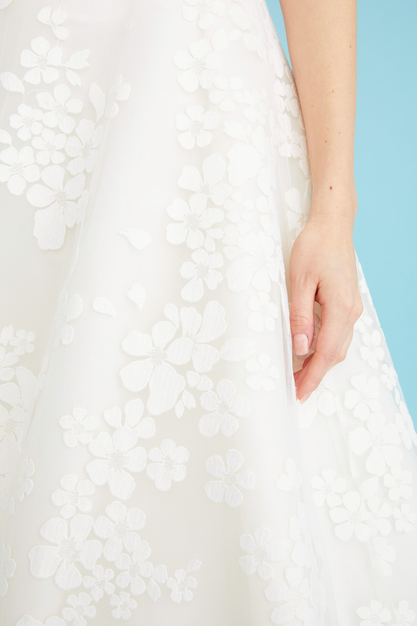 Close-up of the Coralie wedding gown’s cherry blossom-embroidered net fabric, revealing the delicate floral motif and sheer layers of this corset wedding gown by Toronto bridal gown designer Lea-Ann Belter.