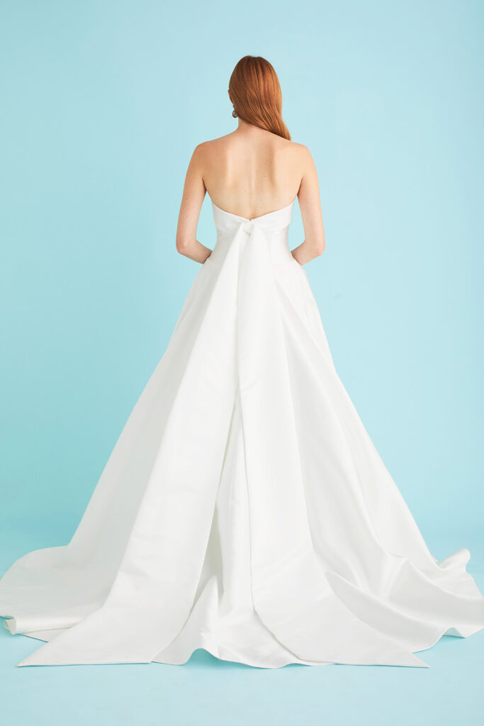 Back view of Hannah, a mikado ballgown wedding dress by Lea-Ann Belter, highlighting long satin back tails and a chapel train.