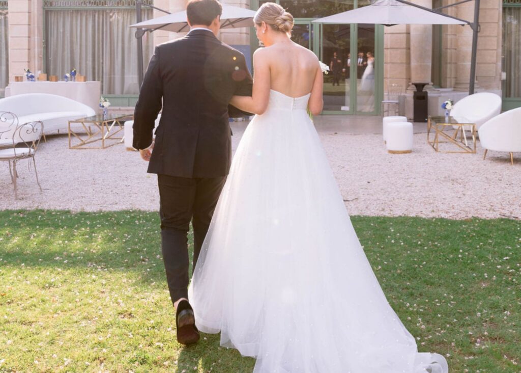 Brooks and Parker walk away in the sunlight on their Paris wedding day. Brooke wears a elegant ball gown wedding dress by Lea-Ann Belter Bridal.