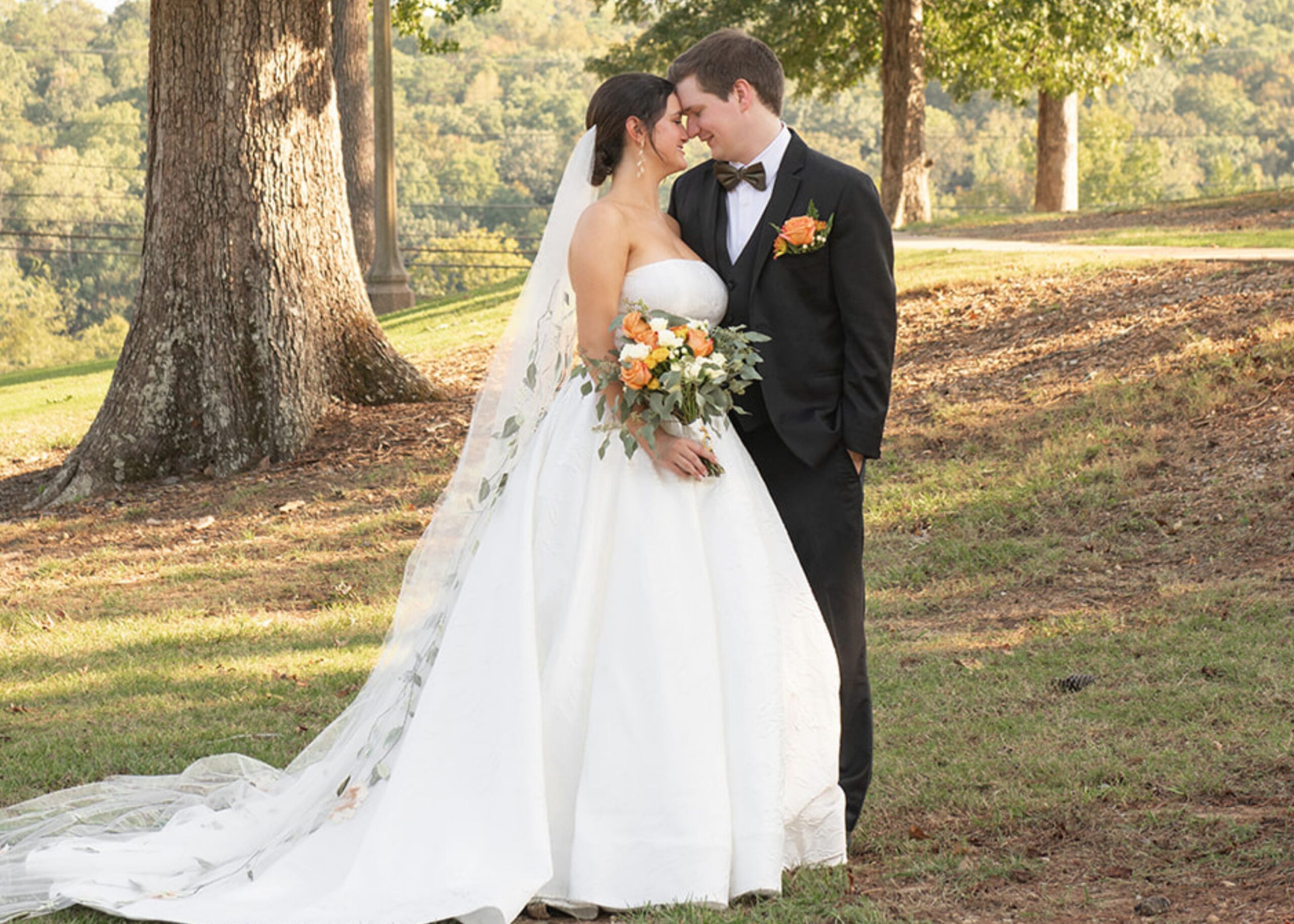 Romantic couple portrait at garden wedding, bride wearing ballgown wedding dress with cathedral length veil