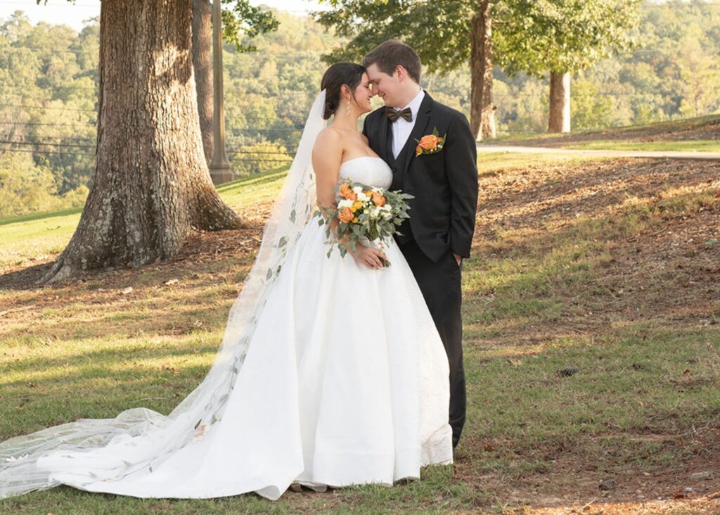 Romantic couple portrait at garden wedding, bride wearing ballgown wedding dress with cathedral length veil