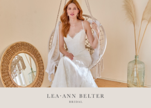 Bride in a Lea-Ann Belter Bridal Toronto lace fit-and-flare wedding dress with scalloped neckline sitting on a hanging chair, surrounded by boho-chic decor.
