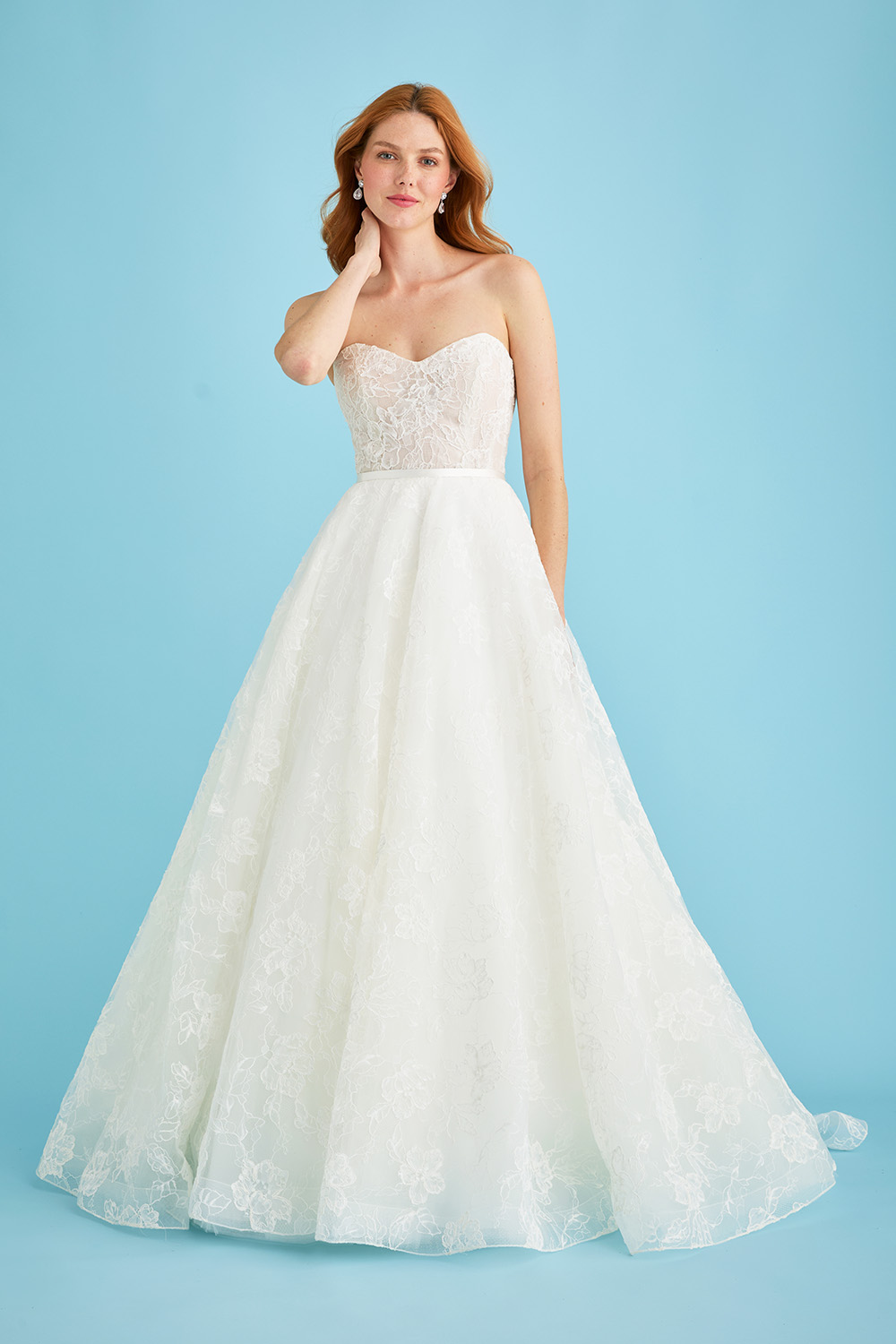 Bride facing forward in the Lea-Ann Belter Bridal Jane circle skirt wedding dress, featuring a sweetheart neckline, sheer lace bodice, and full lace skirt that swirls into a dramatic train. The look is completed with a simple satin belt at the waist.