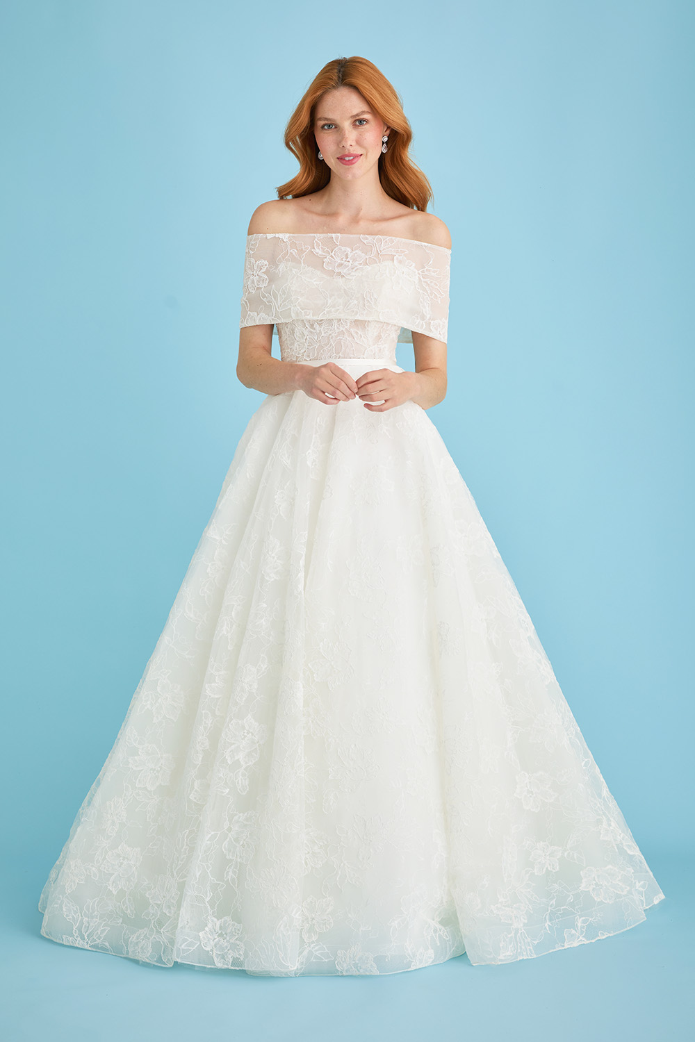 Bride wearing the Lea-Ann Belter Bridal Jane gown with a sheer lace bridal wrap draped off the shoulders. The romantic overlay highlights the floral lace pattern and adds a delicate, ethereal layer to the strapless bodice.