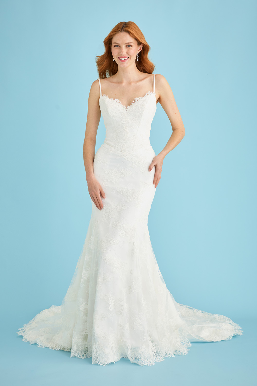 Bride facing forward in the Lea-Ann Belter Bridal Kitty fit-and-flare lace wedding dress, featuring a sweetheart neckline, slim straps, and a body-hugging silhouette that opens below the hips into a soft train.