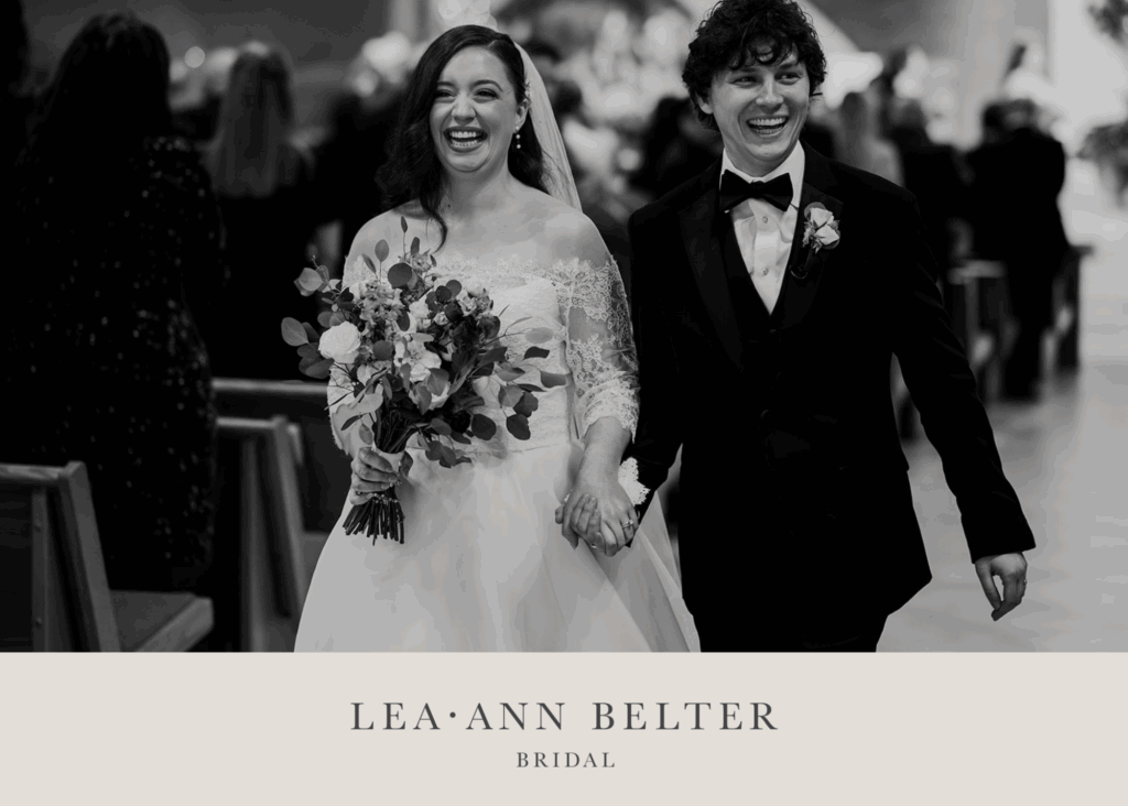Newlyweds Madison and Kyle walk up the aisle smiling, with Madison in a lace bridal bolero and veil, holding a bouquet.