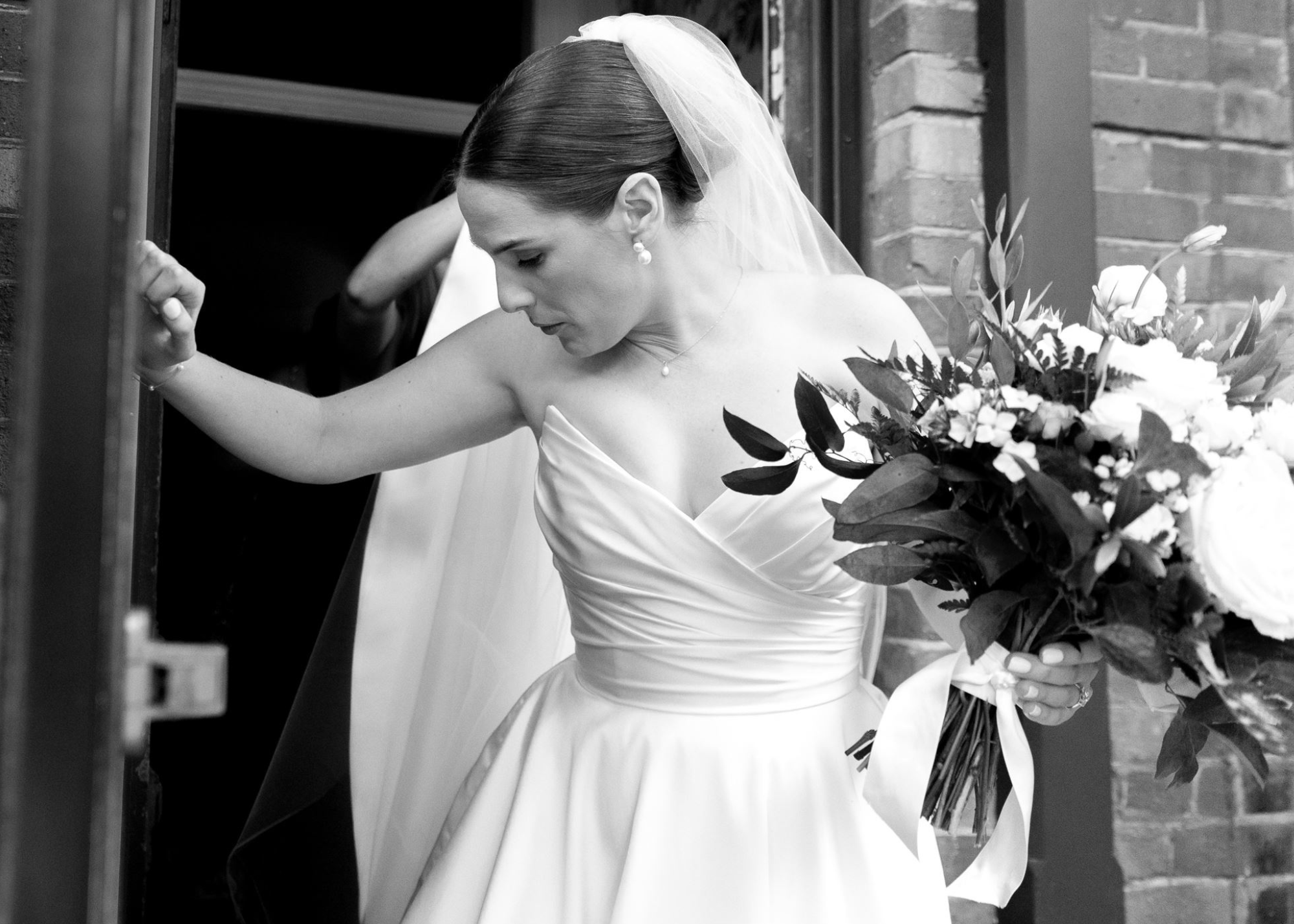 Natalie steps outside in her custom pointed strapless Lea-Ann Belter gown, bouquet in hand and ready for the day
