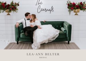 Bride Macy in Lea-Ann Belter's Esperanza gown kissing groom Shane on a green velvet couch at The RoseMary venue