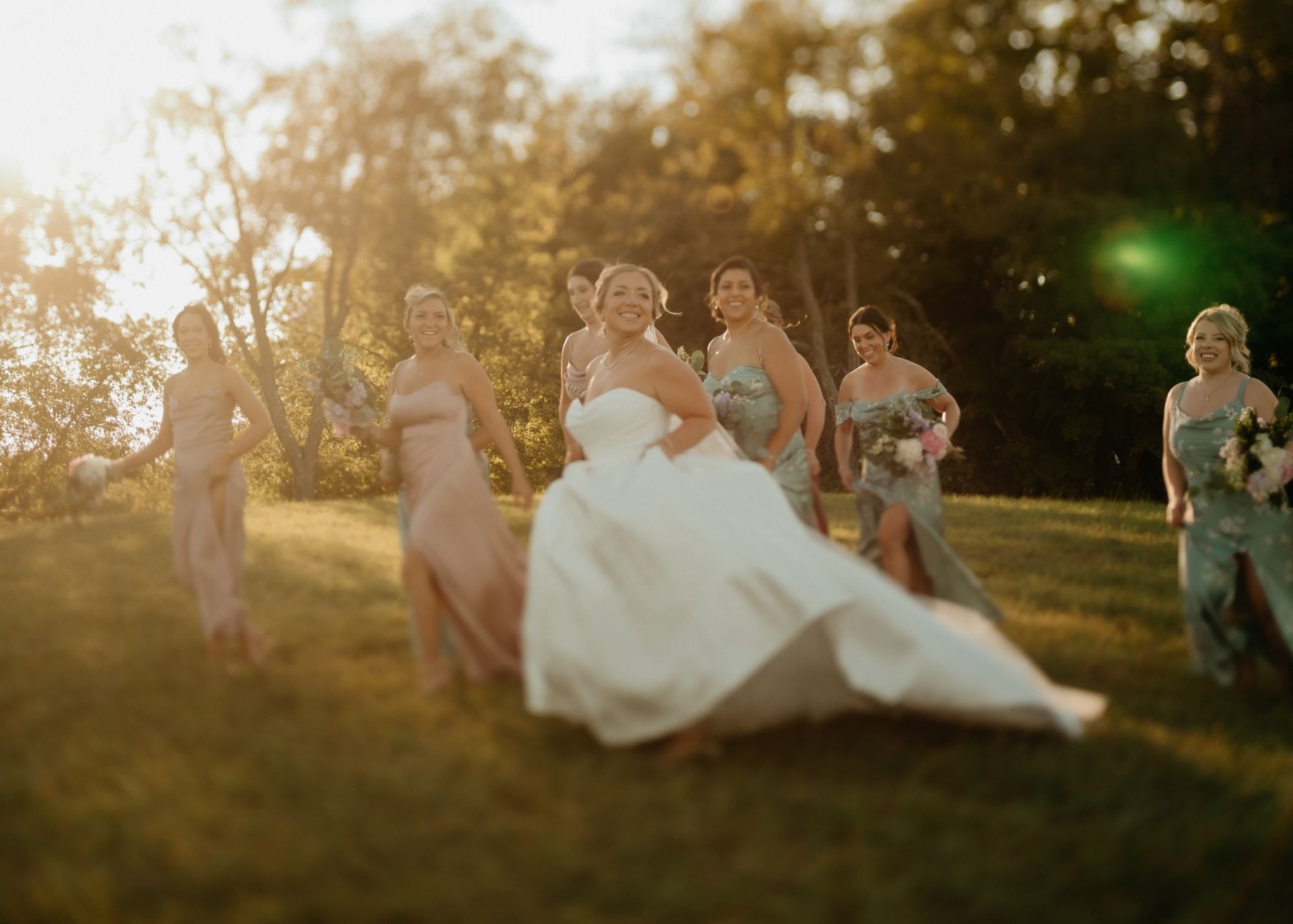 Bride Aileen in Lea-Ann Belter Esme ball gown twirls with bridesmaids in golden sunset at South Farms Connecticut wedding