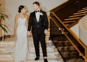 Bride in sleek wedding dress with Swarovski crystal straps and groom in black tuxedo at Ritz-Carlton Toronto wedding