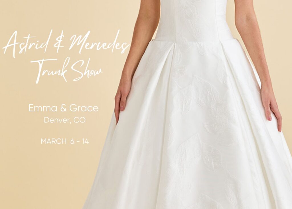 A close of pf the floral textured fabric of a box-pleated ball gown with text that reads: Astrid & Mercedes Trunk Show at Emma & Grace bridal, March 6-14