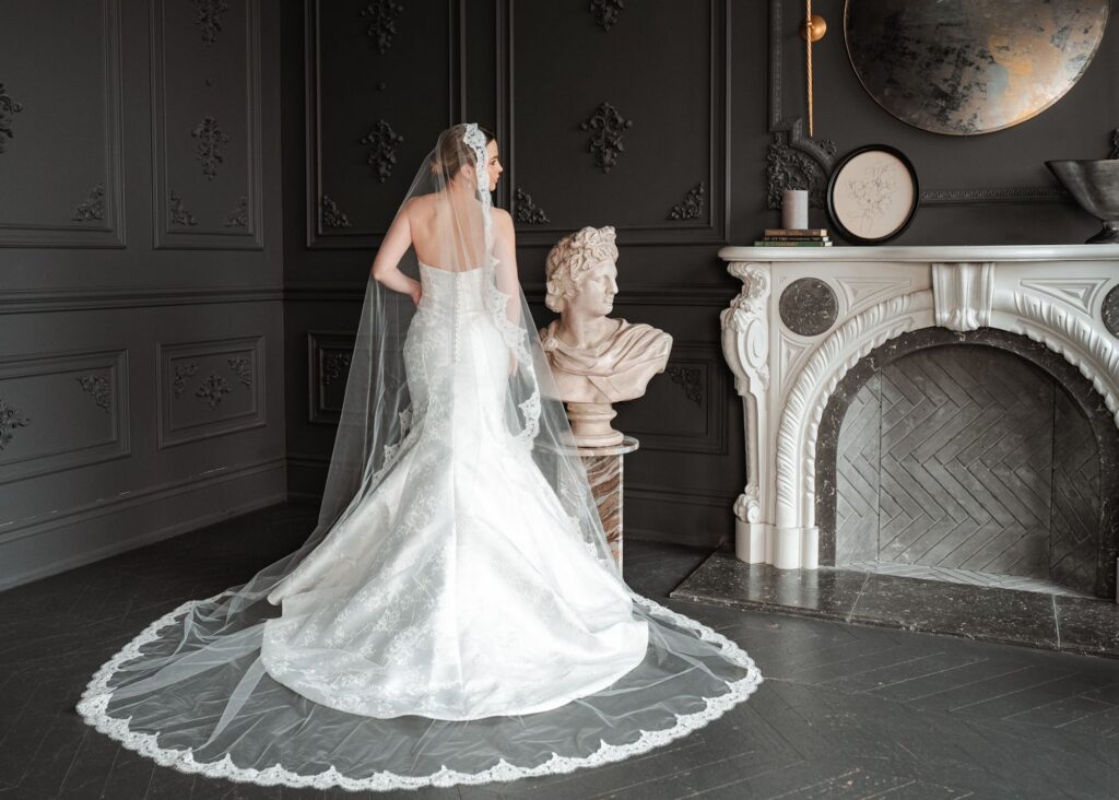 Nicole, an embroidered Mikado fit-and-flare wedding gown by Lea-Ann Belter Bridal, styled with a lace-edged cathedral veil