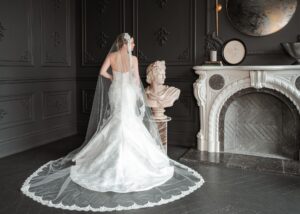 Nicole, an embroidered Mikado fit-and-flare wedding gown by Lea-Ann Belter Bridal, styled with a lace-edged cathedral veil