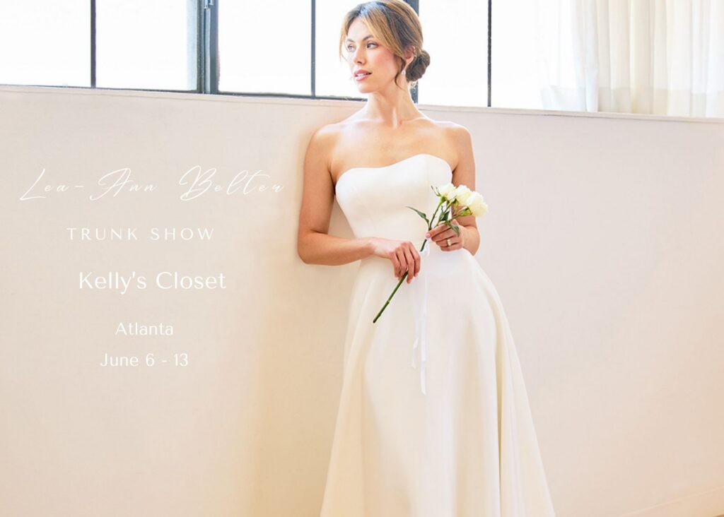 A bride in a sleek wedding dress leans against a wall, holding a bouquet. Text reads - Lea-Ann Belter Bridal Keepsake Collection Trunk show, Kelly's Closet, Atlanta, June 6 - 13