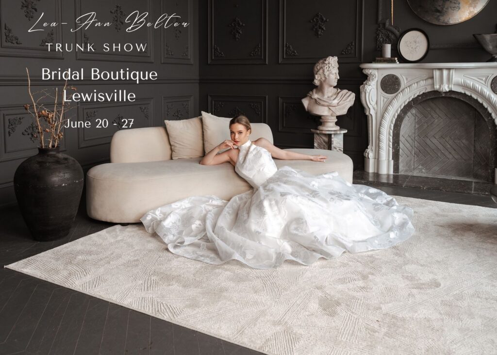 A dramatic photo of a bride reclining on a white couch wearing a halter neck wedding dress with its full skirt spread around her. Text reads: Lea-Ann Belter Bridal Keep sake Collection Trunk Show Bridal Boutique Lewisville June 20-27