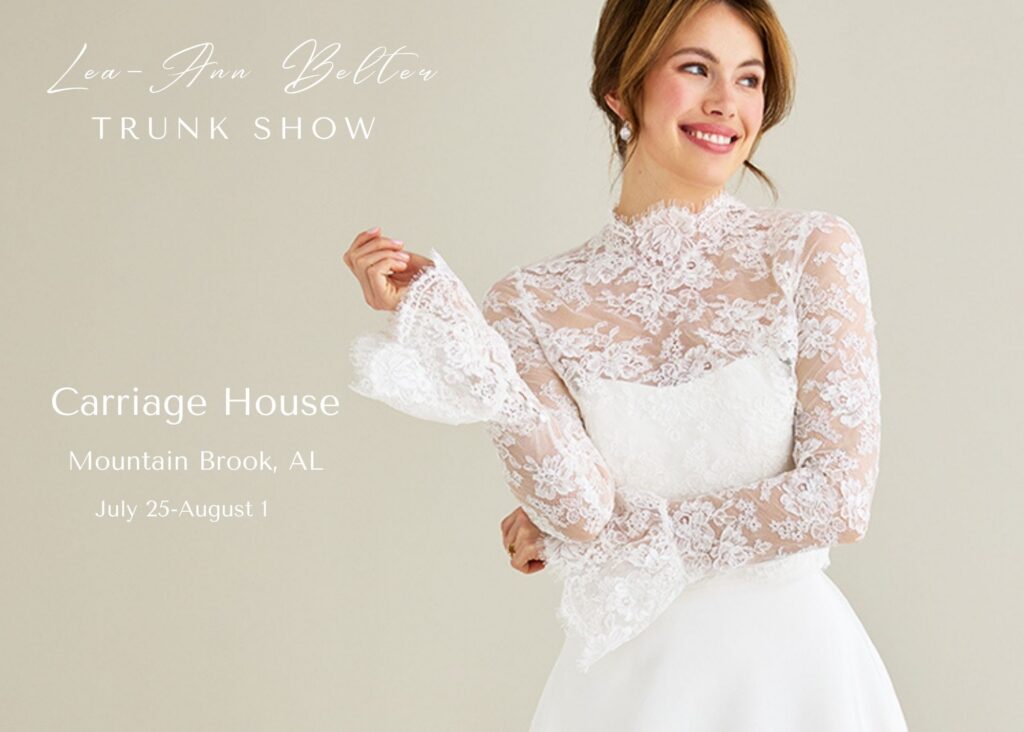 A bride wearing a sheer lace bolero with a hisgh neck and long sleevs over a classic silk crepe wedding dress with her hair piled on her hear.