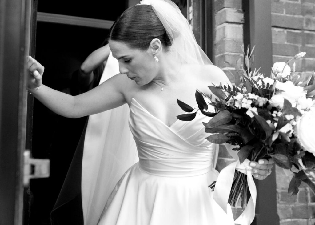 Natalie steps outside in her custom pointed strapless Lea-Ann Belter gown, bouquet in hand and ready for the day