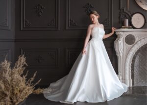 Bride wearing a strapless A-line wedding dress with lace appliqué and chapel train