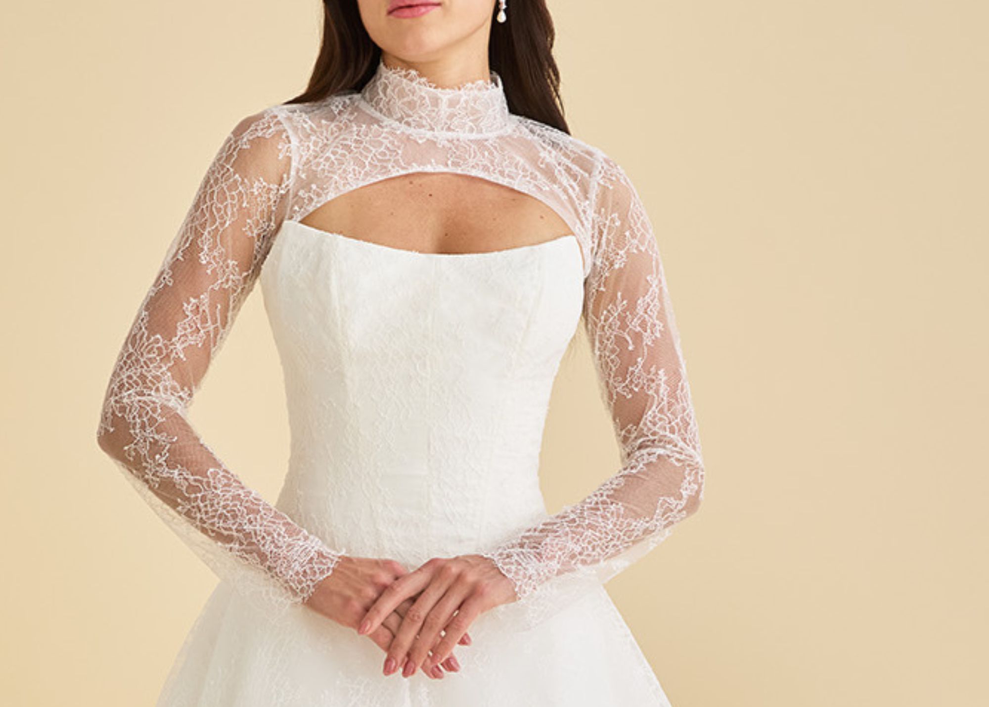 The cat's eye neckline peeks out from under a sheer Chantilly lace topper with long sleeves