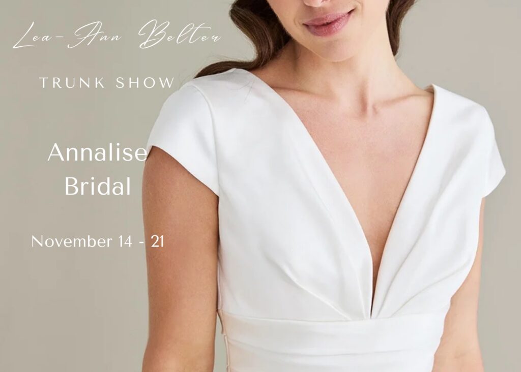 Detail of a model wearing a v-neck, cap sleeved gown with draped bodice. text reads - Lea-Ann Belter trunk show at Annalise Bridal, Richmond, VA, November 14-21