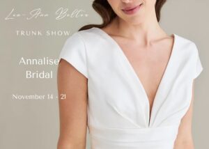Detail of a model wearing a v-neck, cap sleeved gown with draped bodice. text reads - Lea-Ann Belter trunk show at Annalise Bridal, Richmond, VA, November 14-21
