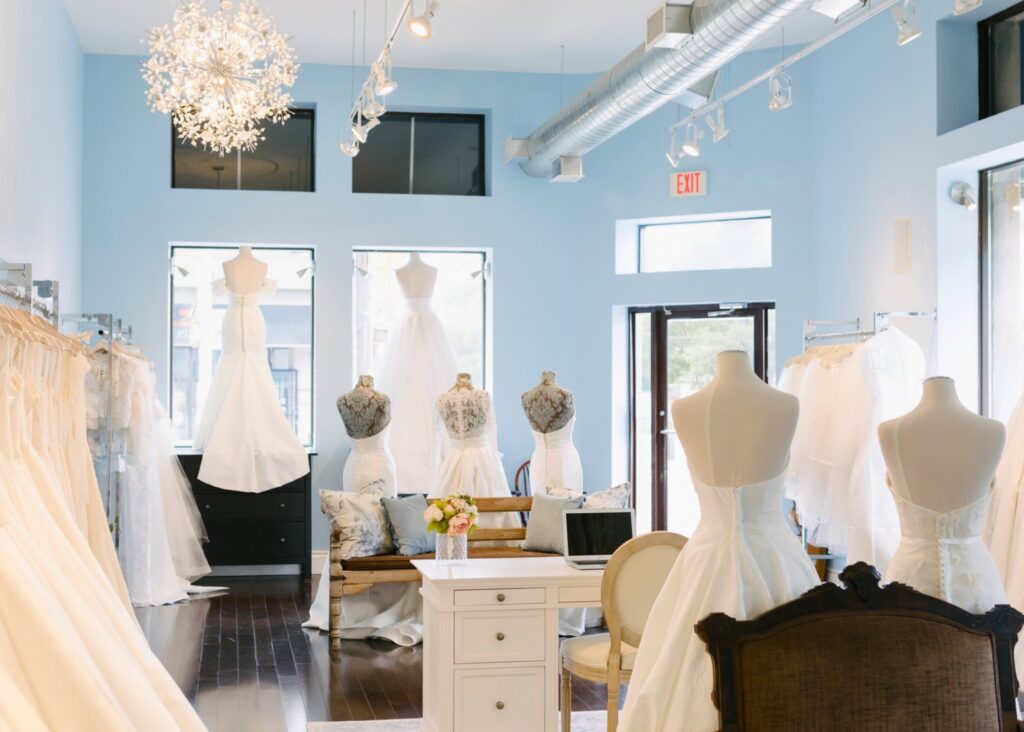 Lea-Ann Belter Toronto bridal shop interior with pale blue walls, a starburst chandelier, and wedding gowns displayed on dress forms and racks