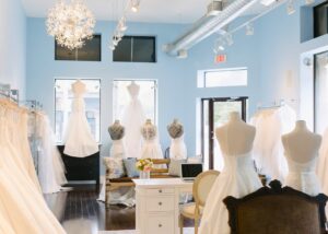 Lea-Ann Belter Toronto bridal shop interior with pale blue walls, a starburst chandelier, and wedding gowns displayed on dress forms and racks